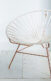 A photo of a chair and a table with a plant in it.