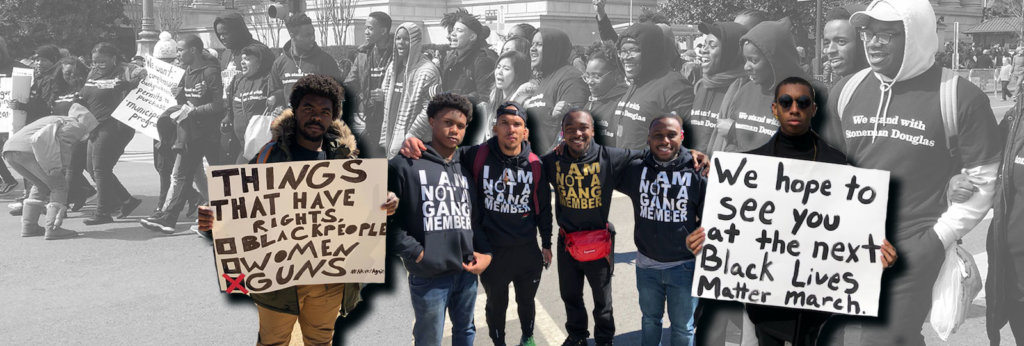 A photo from a protest with Black youth at front, with one holding a sign that says "We hope to see you at the next Black Lives Matter march.