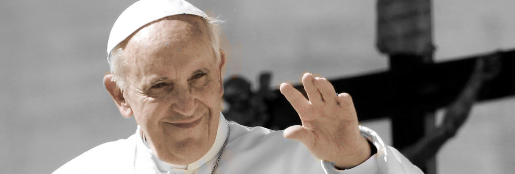 A photo of Pope Francis waving with a cross behind him.