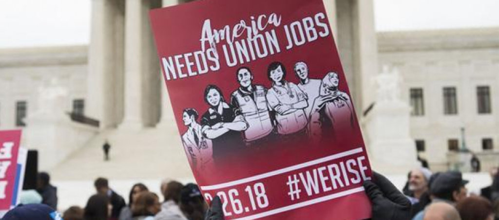 A photo from a protest at the White House. A pamphlet is visible with the text, "America Needs Union Jobs."