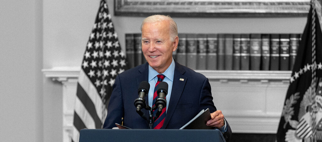 An image of President Joe Biden standing behind a podium at the White House